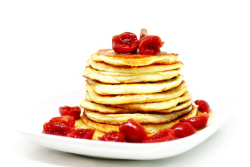 Delicious pancakes with maple syrup and sweet cherries