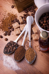 Teaspoons with various coffee lie on a table in an environment o
