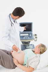 Fototapeta premium Blonde pregnant woman having an ultrasound scan