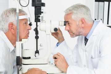 Optometrist doing sight testing for senior patient