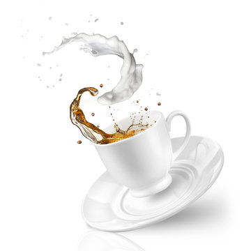 Splash of tea with milk in the falling cup isolated on white