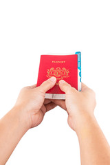 Female hand holding Malaysian passport and boarding pass .