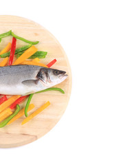 Half of fresh seabass fish on colorful pepper.