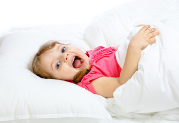Obraz na płótnie Canvas Portrait of a little girl lying in bed