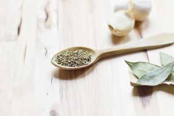 Cuchara de palo con orégano, perejil, laurel y ajos.