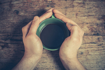 Hands holding a cup of coffee