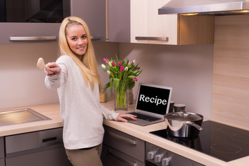 Caucasian woman looking for a receipe on the laptop computer.