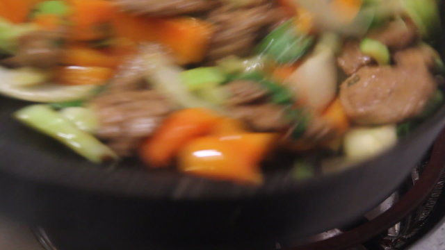 pork stir fry cooking closeup on wok real time