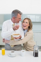 Woman embracing man while having breakfast in kitchen