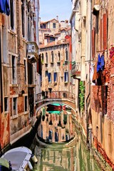 Fototapeta na wymiar Quaint canal in Venice with reflection, Italy