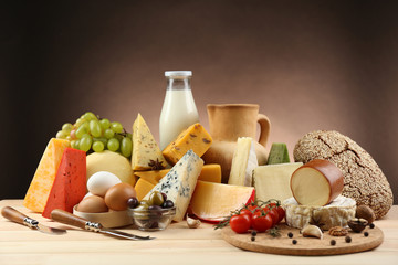 Tasty dairy products on wooden table, on dark background © Africa Studio