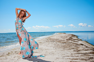 woman in a blue dress on the ocean coast