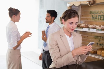 Businesswoman using mobile phone in office cafeteria