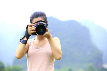 Fototapeta premium young woman photographer taking photo,yangshuo,china