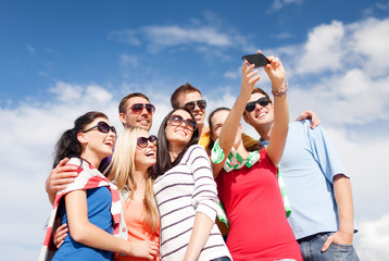 group of friends taking picture with smartphone