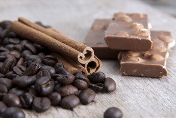 coffee beans, chocolate and cinnamon on wooden table