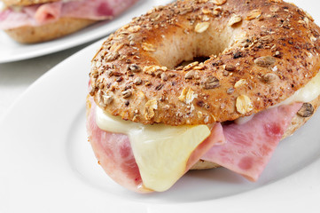 brown bagel filled with ham and cheese
