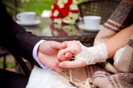 couple holding hands at wooden table