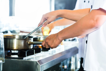 Close up of chef's hands preparing dish