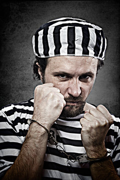 Desperate, portrait of a man prisoner in prison garb, over white