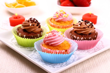 Four appetizing cupcakes on white plate