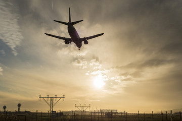 Fototapeta na wymiar Airplane landing at dusk.