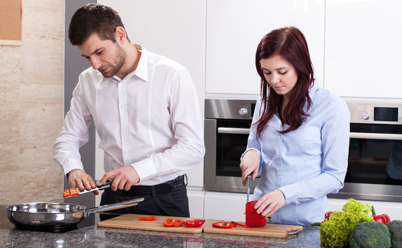 Man and woman cooking dinner