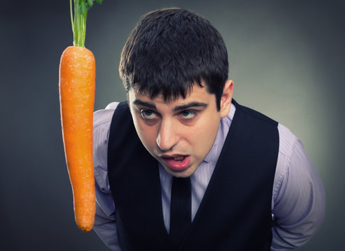 Bait metaphor. Man looking at carrot