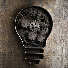 Obraz premium lighting bulb business concept with working gears and cogs in ru