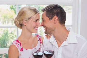 Loving couple with wine glasses looking at each other