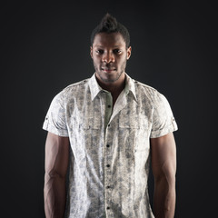 Fototapeta premium Intense black man portrait against dark background.