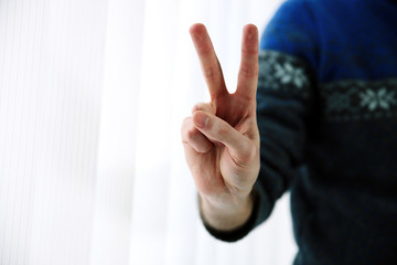 male hand with two fingers up in the peace