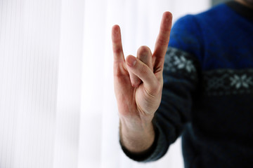 Closeup portrait of a male hand giving the Rock and Roll sign