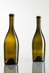 Two empty bottles of wine on a glass table