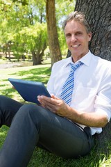 Fototapeta premium Confident businessman with digital tablet in park