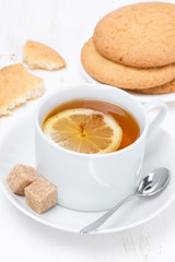 fragrant black tea with lemon and cookies, vertical