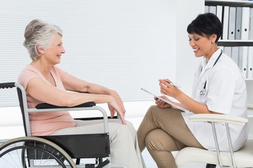Obraz premium Doctor talking to a senior patient in wheelchair
