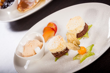 Brownie schokoladenbrownie mit Eiscreme und Pflaumen angerichtet