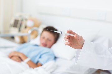 Doctor holding syringe with boy in hospital