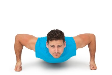 Fototapeta na wymiar Portrait of a determined man doing push ups