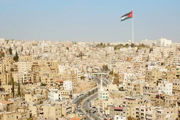 Deurstickers Uitzicht op de stad Amman met grote vlag van Jordanië © andersphoto