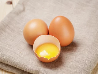 Foto op Plexiglas raw chicken eggs one open with yolk © GCapture