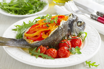 Bream baked fish stuffed with vegetables.