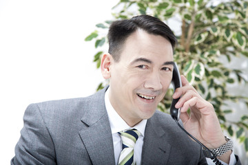 Geschäftsmann mit Telefonhörer in der Hand lächelt