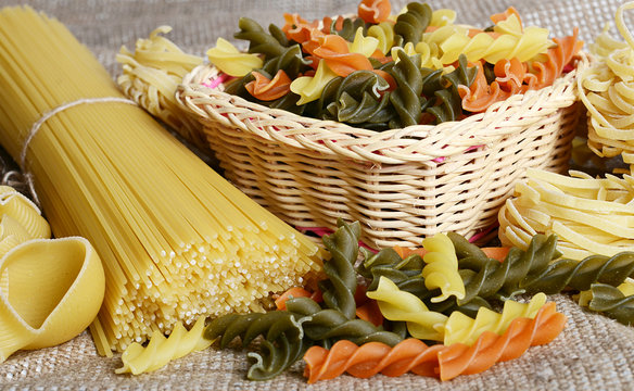 Raw colored pasta fusilli sa a background