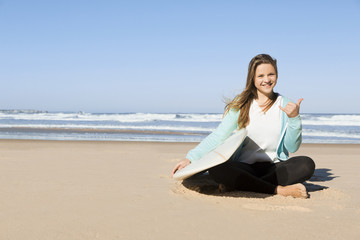 Fototapeta na wymiar Portrait of a teenage girl in the beach sitting on the sand 