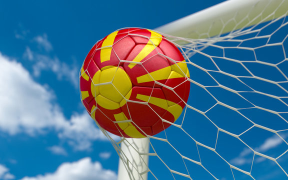 Flag of Macedonia and soccer ball in goal net