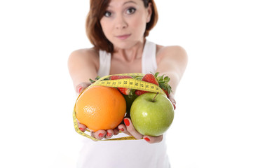 woman hands with fruit  bond with measure tape slave to diet