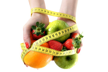 woman hands with fruit  bond with measuring tape slave to diet