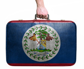 Tourist hand holding vintage leather travel bag with flag of Bel